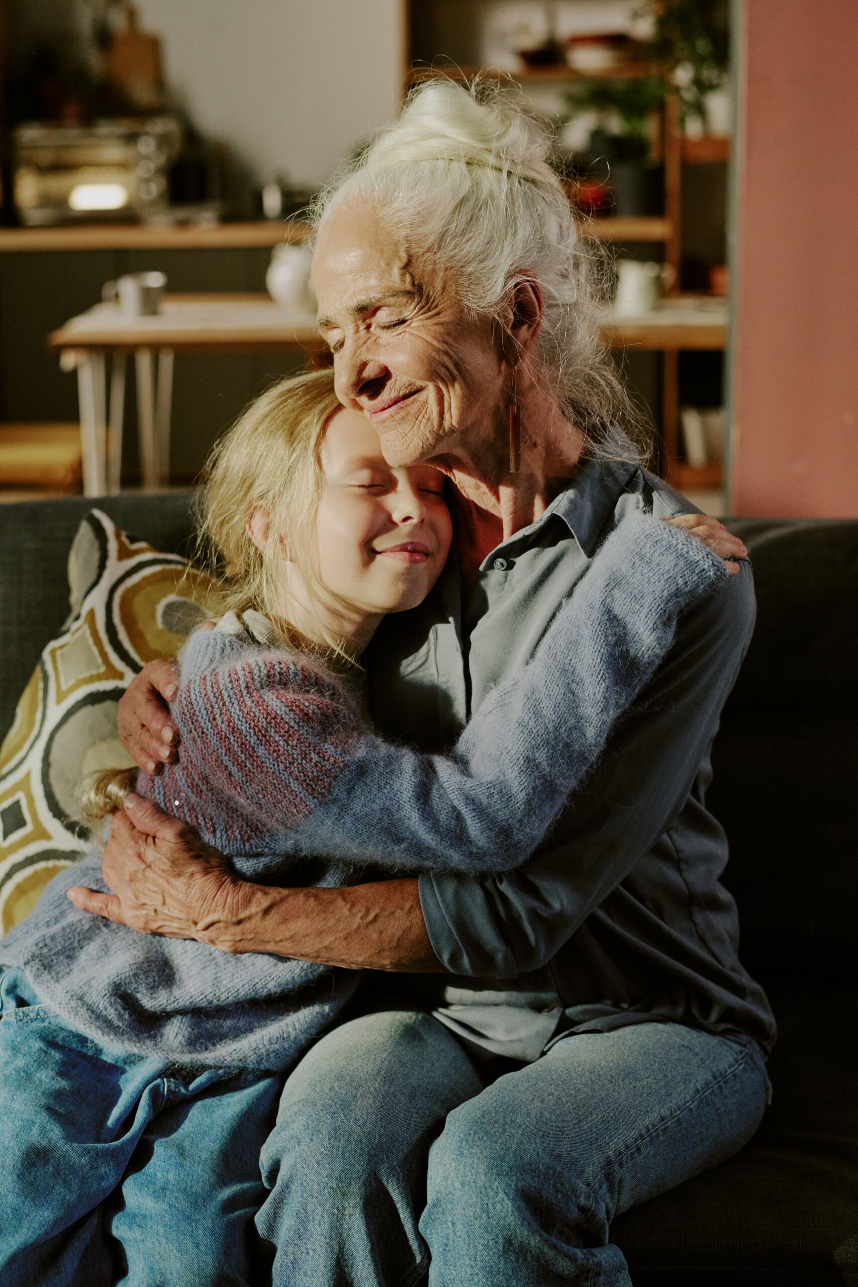 Elderly Woman Embracing Young Child on Sofa